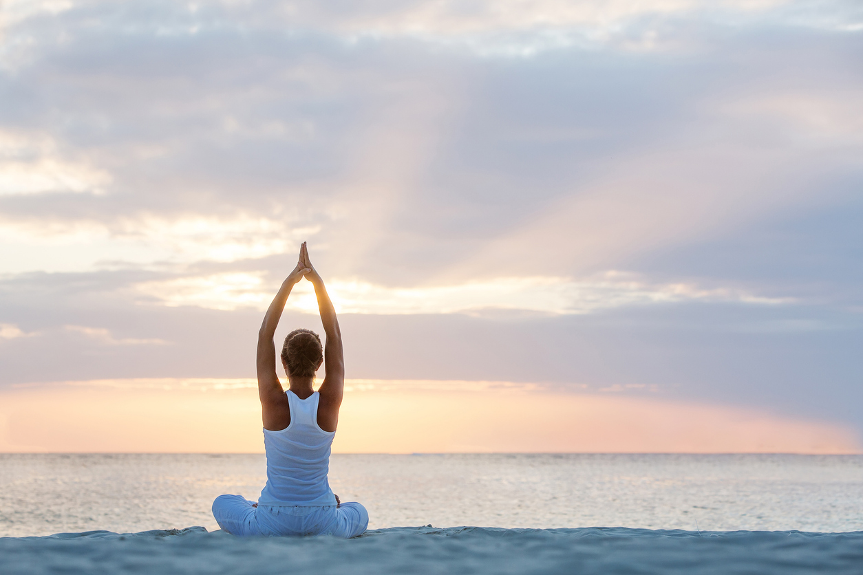 A woman practicing yoga at seashore