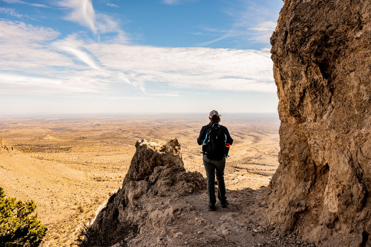 Woman Stands at Viewpoint Over Valley