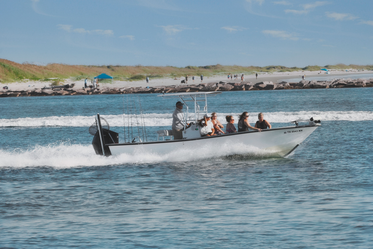 A fishing boat with five female passengers passes a man-made reef