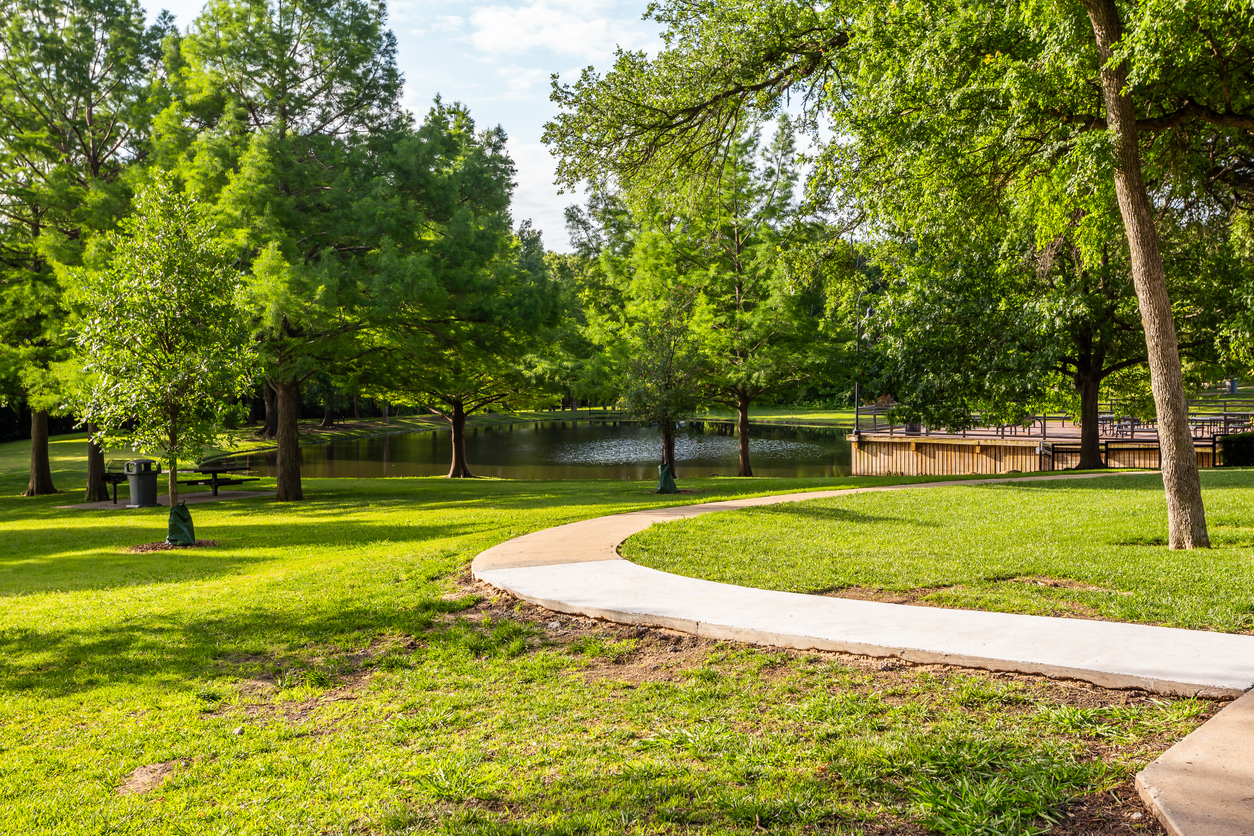 Green lawn and a pond in parking area. Location is Crowley Park in Richardson