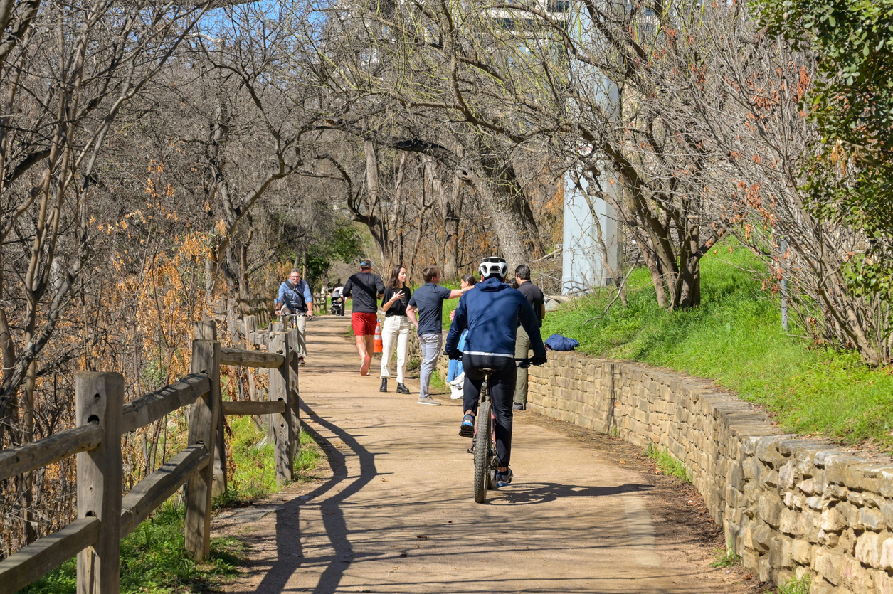 People walking on a path alongside the river in Austin